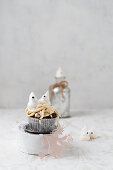 Halloween meringue ghosts on a cupcake with worms