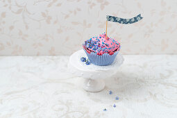 A cupcake with raspberry cream and forget-me-nots