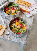 Fruity quinoa salad with chia, vegetables and cashews in to-go containers