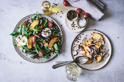 From above plate with gourmet salad made of peaches, red onion, oil and black pepper on white background