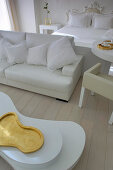 Double bed, couch and coffee table with organic shape in white room