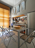 Designer table and plexiglas chairs in open-plan kitchen