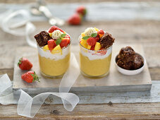 Vegan mango millet pudding with coconut yoghurt, mango and strawberry salad, oatmeal brownies and cashew cream
