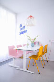 Dining table in white interior with bright accents of bold colour