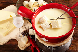 Swiss cheese fondue in a rechaud with a glass of kirschwasser and bread