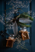 Two jars of honey, gypsophila and glass pine cones on blue surface