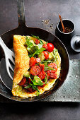 Omelette with Parmesan cheese, cherry tomatoes, avocado and chorizo
