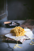 Appetizing dry pasta on tablecloth on table