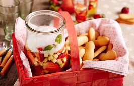 strawberry and apple punch with cider and sparkling wine in a picnic basket with biscuits