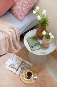 Vases of flowers on side table next to sofa bed