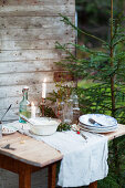 Rustikal gedeckter kleiner Tisch an Holzhütte