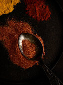 Spices and spoon on black background