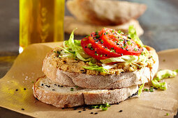 Brot mit selbstgemachtem Hummus, Salatstreifen und Tomate