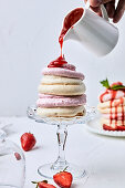 Small strawberry pavlova drizzled with strawberry sauce