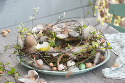 Easter wreath made of branches, decorated with eggshells, feathers and onions