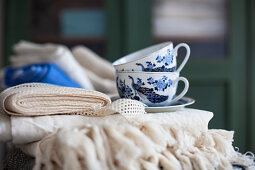 Folded tablecloths and blue-and-white cups