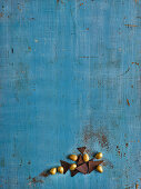 Golden chocolate eggs and pieces of chocolate on a blue surface