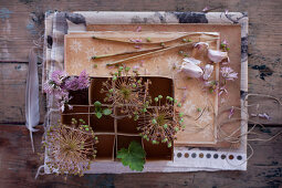 Vintage-style arrangement with garlic cloves, flowers and cardboard box