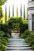 Weg mit großen Steinplatten zur Terrasse im sommerlichen Garten