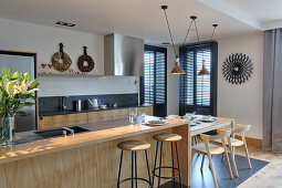 Kitchen counter with bar stools and breakfast table at one end