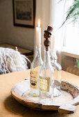 Stoppers and candles in vintage bottles on wooden tray