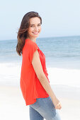 A young brunette woman wearing a red blouse and jeans