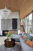 Grey sofa set and coffee tables in front of fireplace with firewood rack