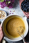 Mixing a cake mixture in a mixing bowl surrounded by ingredients