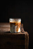 Dark Iced Latte in a jar on a wooden table