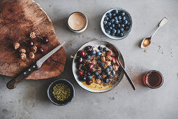 Breakfast Bowl mit Joghurt, Quinoa, Kokos, Kirschen und Blaubeeren