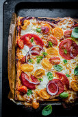 Quadratische Pizza mit Tomaten, Mozzarella und Petersilie