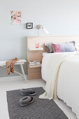 Double bed with wooden headboard in bright bedroom