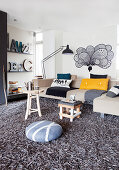 Helle Sofagarnitur und Regal mit Dekobuchstaben im Wohnzimmer mit grauem Hochflorteppich