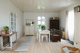 A Scandinavian-style dining room with ceiling panelling and wooden floorboards