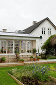 Terrace and a winter greenhouse with lattice windows, and garden beds