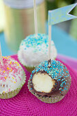 Mit Zuckerperlen dekorierte Cake Pops mit Fähnchen