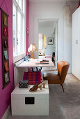 Desk and retro leather armchair below window flanked by hot-pink walls