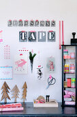 Collage mit Buchstabenschablonen an der Wand überm Schreibtisch