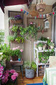 Üppig bepflanzter Balkon mit sommerlichen Blumen und Pflanztisch