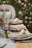 Linen napkins decorated with roses on set table in garden