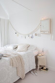 Double bed in festively decorated, white bedrom