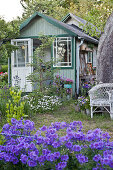 Picturesque summerhouse in flowering summer garden