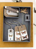 Geschenkanhänger aus Papier mit Schmetterling-Motiven in einer Schachtel