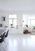 A view of a white lowboard and a seating area next to a dining area