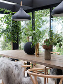 Self-made wooden dining table with classic chairs in the winter garden