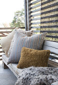 A bench with cushions on a terrace