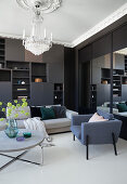 Dark living room wall, upholstered furniture, round coffee table and chandelier