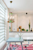 Acrylic chairs at a glass table in a modern kitchen-living room