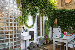 A table laid in a back garden with Virginia creeper growing against a wall