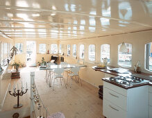 Offene Küche mit Gasherd und Esstisch in einem Hausboot
